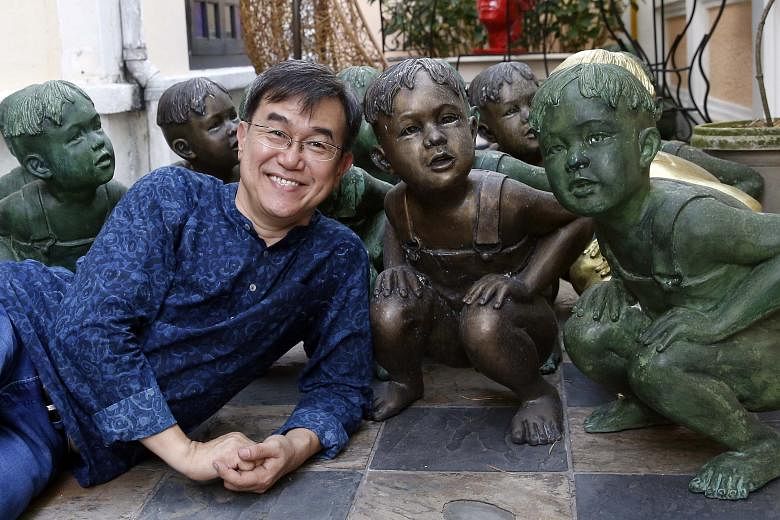 Mr Sim, with the sculptures of a boy squatting down, in his Katong home. He said the boy represents his three-year-old self having to do his business in the open in the kampung he used to live in, adding: "We've come a long way since then."
