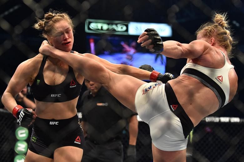 Holly Holm (right) landing a kick to the neck to knock out bantamweight defending champion Ronda Rousey in the UFC title fight in Melbourne yesterday.