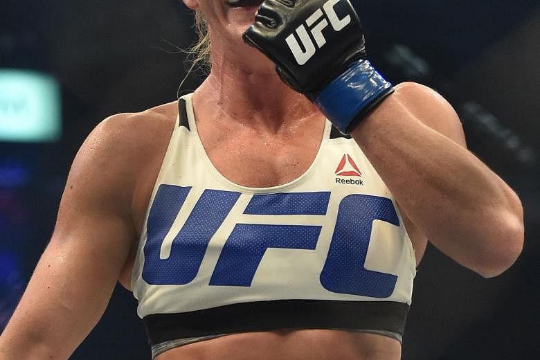 Holly Holm (right) landing a kick to the neck to knock out bantamweight defending champion Ronda Rousey in the UFC title fight in Melbourne yesterday.