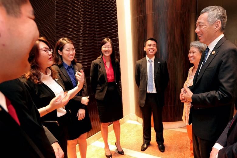 (From left) Undergraduates Ophelia Chew, Yang Jin and Ong Sim - three of the five youth picked to represent Singapore as part of a youth delegation at the Apec summit - speaking with Prime Minister Lee Hsien Loong and his wife, Mrs Lee, at the Fairmo