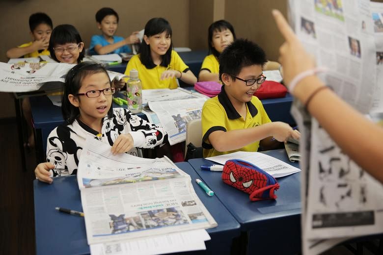 Fyndy Siom Wen Jing (front) and her friends at a newspaper reading session at Groworld Learning Tuition Centre, where pupils are encouraged to think more in depth before they answer questions.