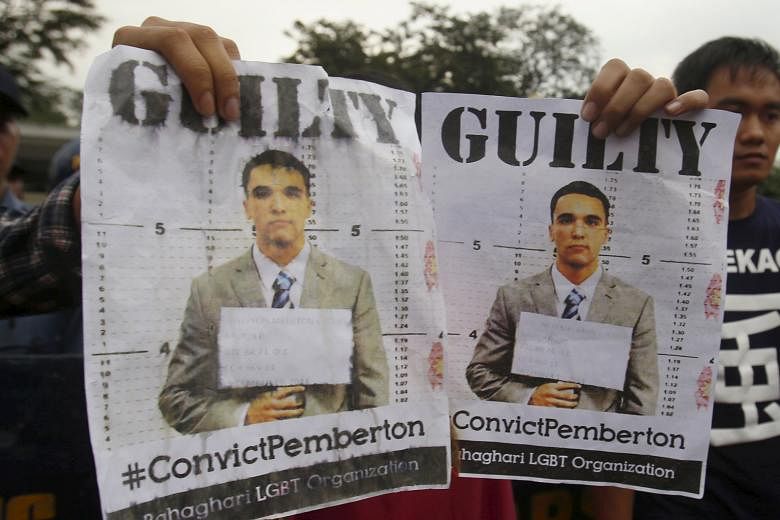 Activists in Manila with posters of US Marine Lance Corporal Joseph Scott Pemberton, who was found guilty of homicide yesterday in the killing of Filipino transgender person Jeffrey Laude last year.