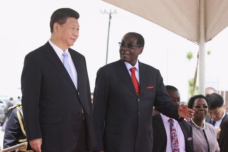 Chinese President Xi Jinping being welcomed to Zimbabwe by President Robert Mugabe yesterday. Mr Xi is expected to use his five-day visit to Africa to showcase China's expanding role as a protector of regional security, a revision of the country's ha