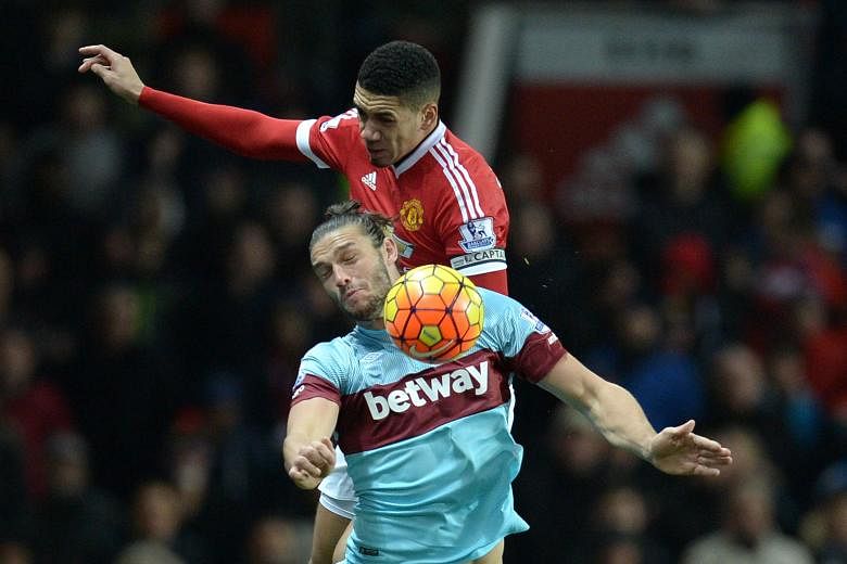 Manchester United defender Chris Smalling (top) keeping Andy Carroll and Co quiet in a 0-0 home draw with West Ham on Saturday to continue an impressive run. He had 22 straight league starts and helped to keep nine clean sheets this season - more tha