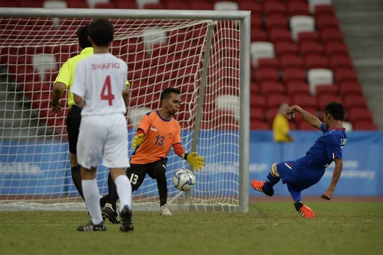 Thailand's Sanya Suksang (left) scoring past Singapore goalkeeper Firdaus Nor. The Thais played attacking football and Sanya netted twice in the 5-0 win.