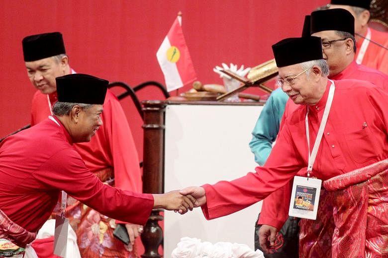 Umno president and Malaysian Prime Minister Najib Razak (right) shaking hands with former deputy prime minister and Umno deputy president Muhyiddin Yassin during the party's general assembly. The leader's closing speech was directed at dissenters led
