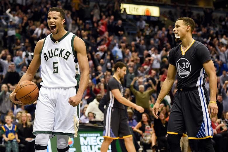 Bucks guard Michael Carter-Williams (left) reacting in front of Warriors guard Stephen Curry after a Bucks basket late in the fourth quarter. The Bucks beat the Warriors 108-95.