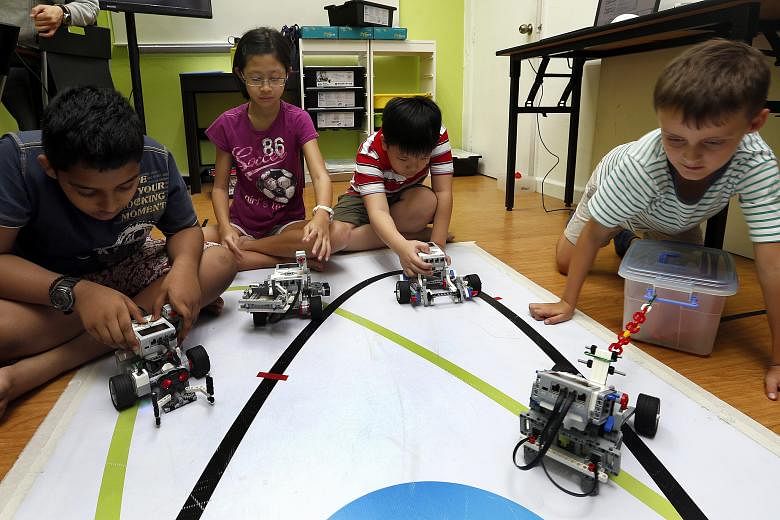 Pupils (from left) Shakthi Vel. P, 10; Marissa Koh, 11; Foo Sze Xiang, seven; and Olivier Bhogal, seven, at a robotics workshop at In3Labs. Marissa, a Holy Innocents' Primary School pupil, said she enjoyed the building process the most.