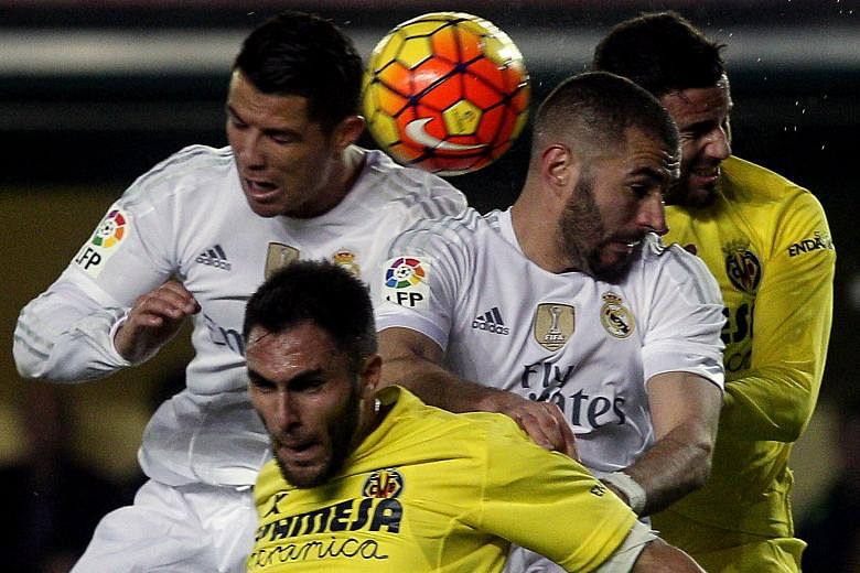 Real Madrid forwards Cristiano Ronaldo (left) and Karim Benzema (centre) vying for the ball in a tight aerial tussle against Villarreal defenders Victor Ruiz (front) and Mateo Musacchio (right). Real suffered a surprise 0-1 loss in the La Liga encoun