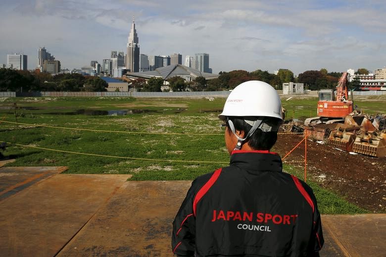 An official overlooks the empty site of the planned national stadium, the centrepiece of the Tokyo 2020 Olympics.