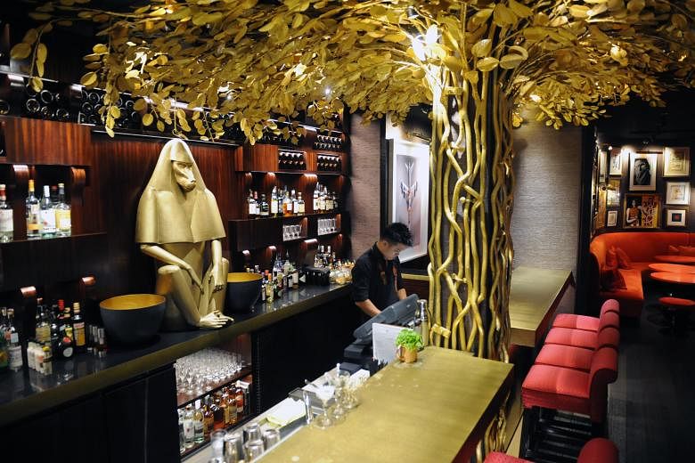 A golden baboon watches over the bar of Hotel Vagabond. Handpainted screens (far left) conceal the bathrooms, while artworks and photographs add visual appeal in rooms (left).