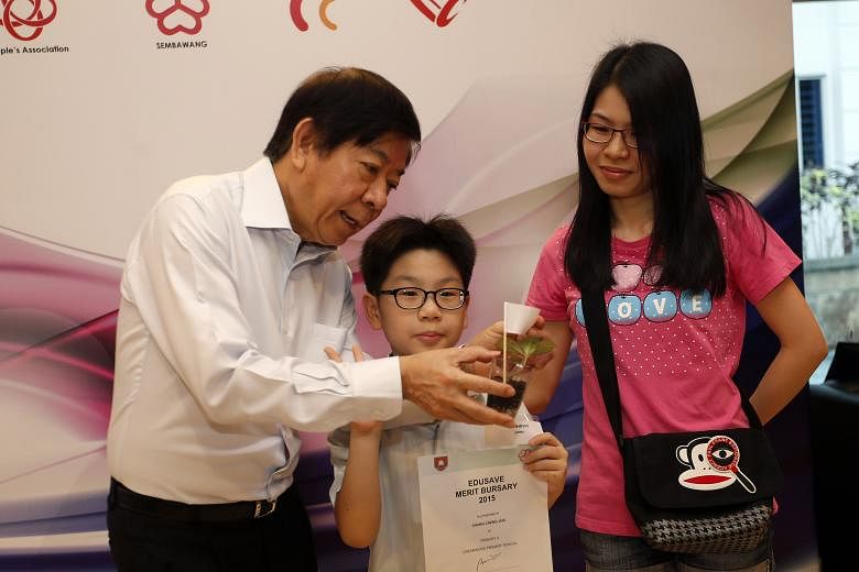 Greenwood Primary School pupil Chang Cheng Jun took home an Edusave Merit Bursary award yesterday. He and his mother also got a photo with Sembawang GRC MP Khaw Boon Wan, who gave out the awards.