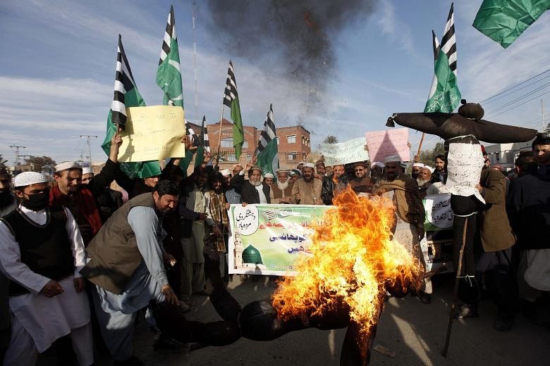 Pakistani supporters of Rah-e-Haq religious party in Peshawar burning an effigy representing Iran, Israel and the US at a rally on Tuesday in favour of Saudi Arabia's execution of Shi'ite cleric Nimr al-Nimr.