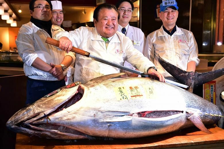 Mr Kiyoshi Kimura (centre), who owns a sushi restaurant chain, showing a 200kg bluefin tuna at his restaurant in Tokyo.
