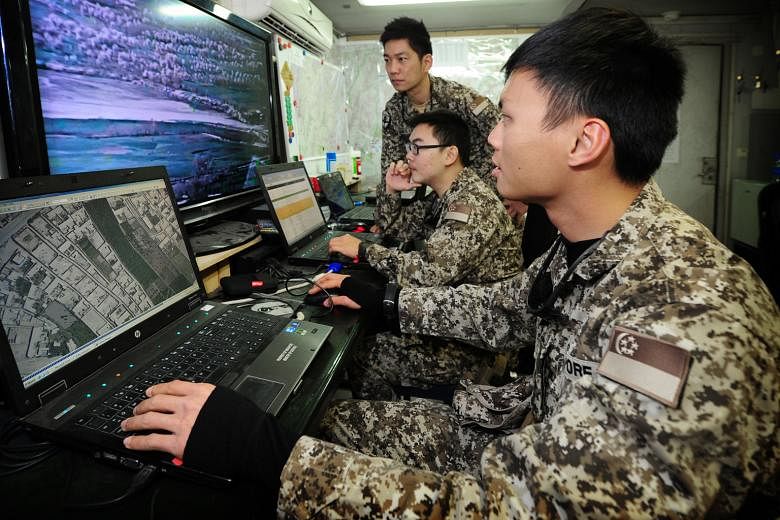 Members of the Singapore Imagery Analysis Team at a multinational base in Afghanistan in 2014. The team has provided useful intelligence support to the multinational coalition fighting ISIS at its headquarters in Kuwait.