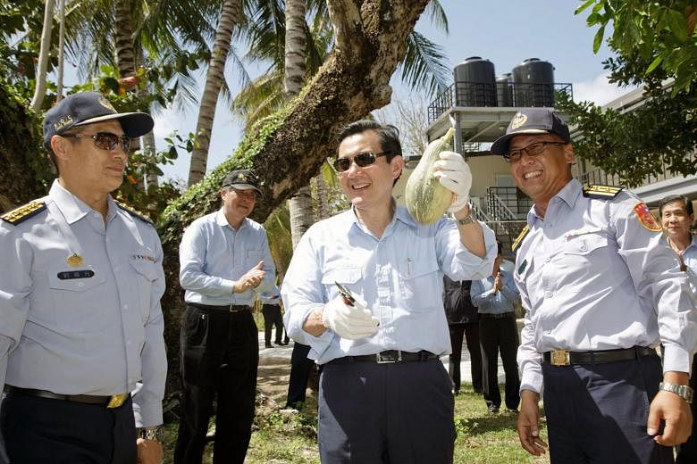 Outgoing Taiwanese President Ma Ying-jeou holding a papaya during his visit to Itu Aba, or Taiping Island, in the South China Sea yesterday. The purpose of the trip was to visit Taiwanese personnel stationed there ahead of the Chinese New Year holida
