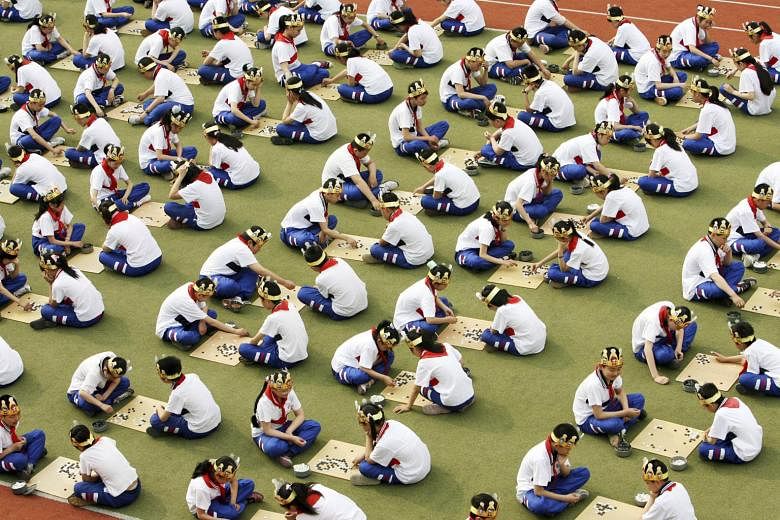 Students in China playing Go, known as Weiqi in Chinese, during a competition. The board game invented over 2,500 years ago typically consists of a 19-by-19 square board, where players attempt to capture empty areas and surround an opponent's pieces.