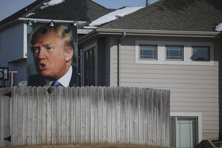 A poster of Mr Trump in a supporter's backyard yesterday in Des Moines, Iowa. Mr Trump would likely have been questioned on his recent suggestion that Iowans, the people whose votes he is courting, are stupid.