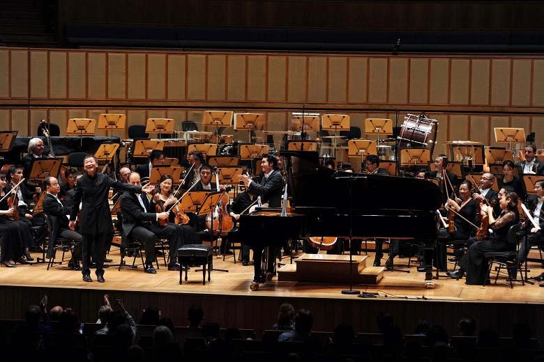 SSO's anniversary concert was conducted by Darrell Ang (left) and featured pianist Melvyn Tan (standing).