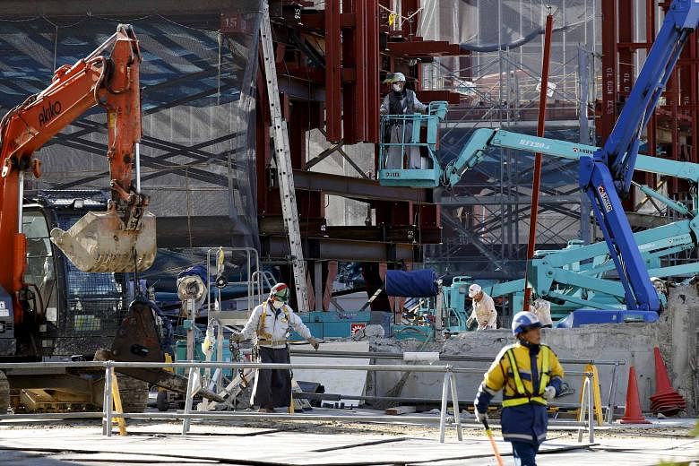 Workers constructing a commercial building in Tokyo. There is huge demand for infrastructure in the region but most of the needs remain unmet. By 2025, infrastructure needs in Asia are expected to reach US$5.36 trillion (S$7.6 trillion) annually.