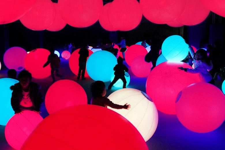 The interactive art installations include one with projections of butterflies and flowers (above) and another of large lit balls that change colours and produce sound when touched (left).