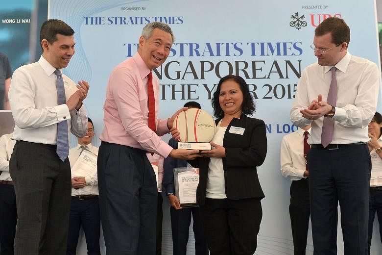PM Lee presenting Madam Noriza with the Singaporean of the Year trophy at the UBS Business University yesterday. With them are Straits Times Editor Warren Fernandez (left) and Mr Juerg Zeltner, president of UBS Wealth Management. Madam Noriza hopes h