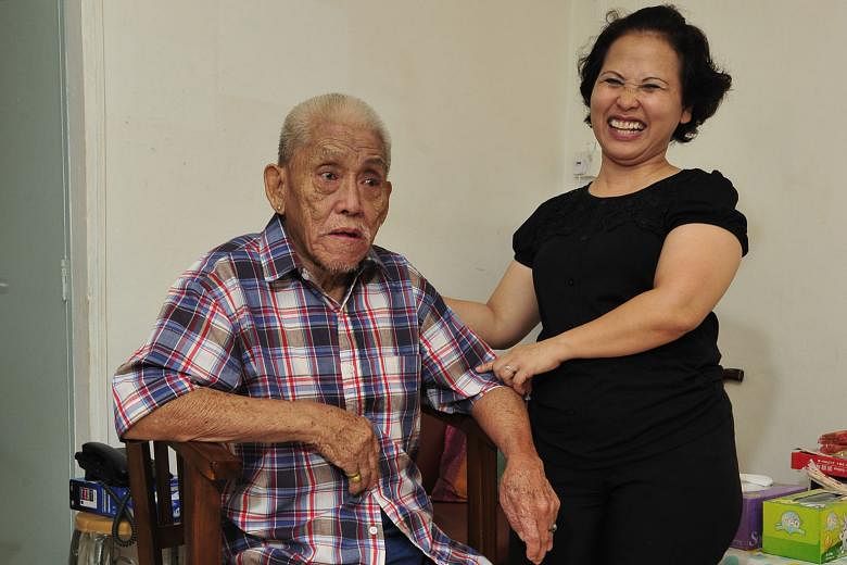 Madam Noriza with Mr Tan at his home, in a photo taken last year. Since her selfless act in 2014, she has spent nearly all her days off visiting him and his wife in their flat and later in hospitals and nursing homes.