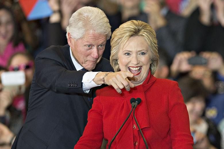 Mrs Hillary Clinton with her husband, former US president Bill Clinton, at a caucus night party in Des Moines, Iowa, on Monday. Mrs Clinton had the narrowest of wins over Senator Bernie Sanders on the Democratic side.