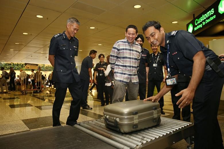 Mr Amrin, accompanied by ICA Deputy Commissioner of Operations Aw Kum Cheong (left), witnessing baggage screening at Changi Airport Terminal 3 yesterday.