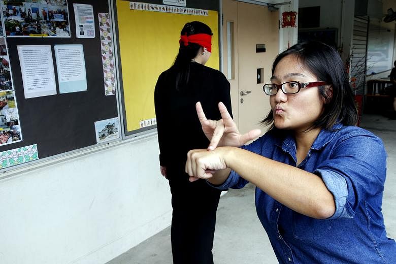 Miss Loh getting a participant, who is blindfolded and wearing earplugs, to experience what it is like to be deaf-blind, during her talk on Jan 31.