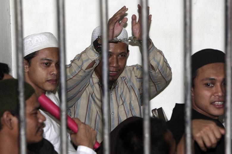 Aman Abdurrahman (centre) in a holding cell with other militants during their trial in Jakarta in 2010. Aman is now suspected to be the prime instigator of the Jan 14 terror attack. Days before it happened, he had issued a decree from prison telling 