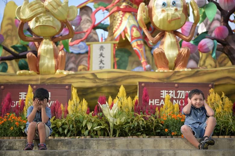 Three-year-old Francisco Tapia (left) and his brother Pedro, five, posing for a shot by their parents during a visit to the opening of the River Hongbao 2016 light-up, yesterday. The Ecuadorian family of four are in Singapore on a holiday.