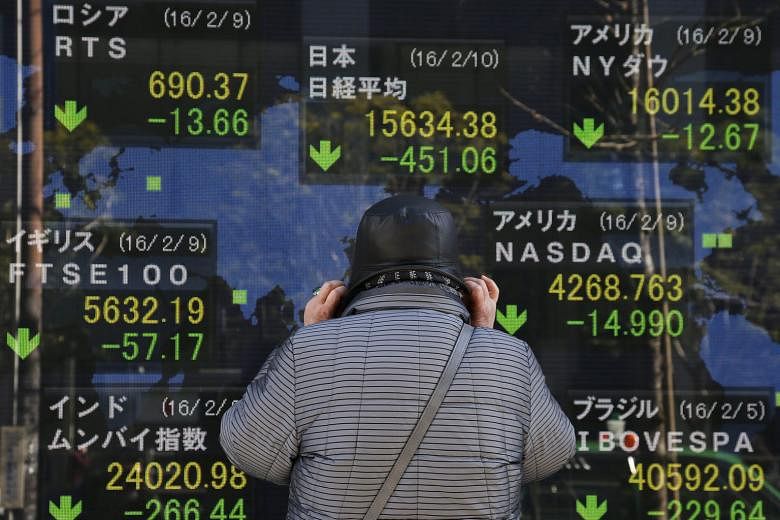 A man studying Nikkei Stock Average data in Tokyo yesterday. Banking stocks have been hit very hard since the central bank introduced negative rates.