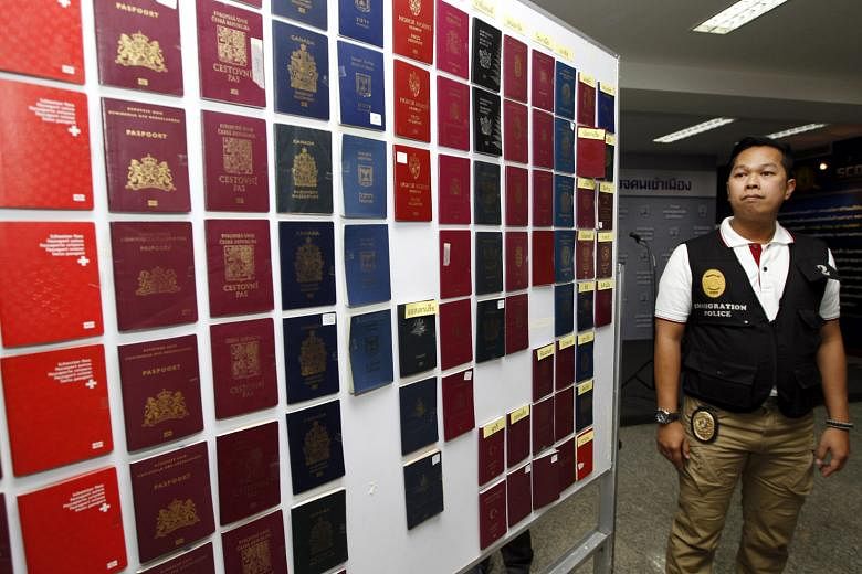 Fake passports (above) on display ahead of a press conference in Bangkok on Tuesday. Hamid Reza Jafary (left) allegedly produced thousands of passports for Middle Eastern clients.