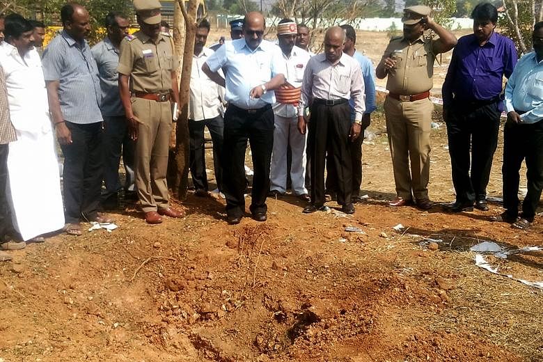 The authorities inspecting the 2m-wide crater on Sunday. Tamil Nadu's Chief Minister says that a bus driver was killed on Saturday by a meteorite strike at the site in Vellore district.