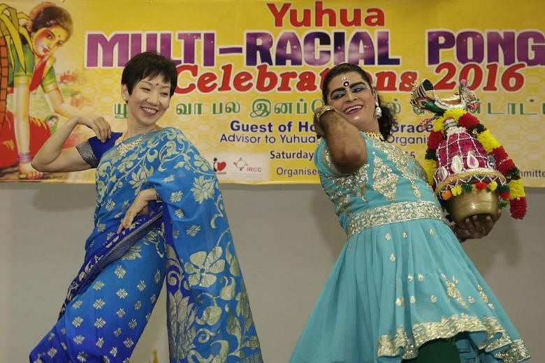 Dressed in a sari, Minister for Culture, Community and Youth Grace Fu joins a male dancer to perform the ancient folk dance Karagattam at the Yuhua Community Club yesterday. The dance, popular in the villages of rural India, was part of a joint celeb