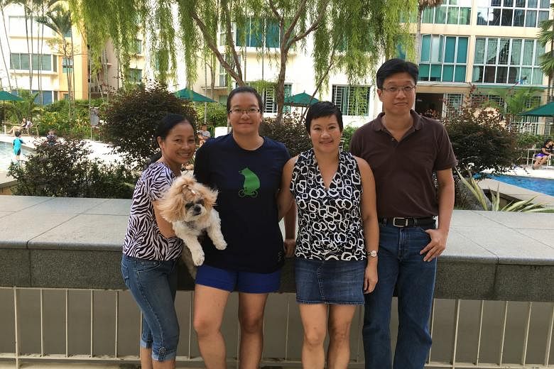 Miss Melissa Tan (second from left) with her parents Maria and Wilson, and their helper Mila (carrying their dog Silver). Miss Tan enjoys reading and engaging in scientific research.