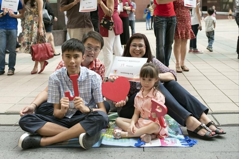 Striking the "love" pose to celebrate World Marriage Day are Ms Joyce Mehar and her husband of 19 years, Mr Ronald Khoo, as well as their children, 16-year-old Jeremy and four-year-old Ropheka.