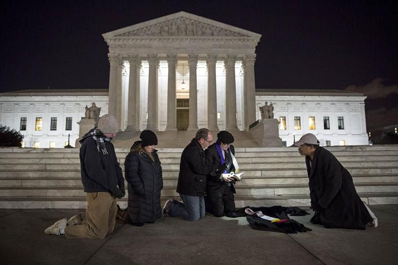 People praying in front of the US Supreme Court in Washington, DC. Justice Antonin Scalia, who died in his sleep last Saturday, was a staunch defender of the values of conservative America.