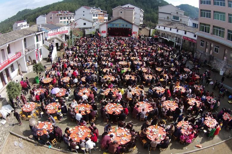 People turned up in force at a village square (top) to have lunch with family members and friends to celebrate the Spring Festival in Taizhou, Zhejiang province, last Thursday. Meanwhile, others queued to enter a shop (above) in Florentia Village in 