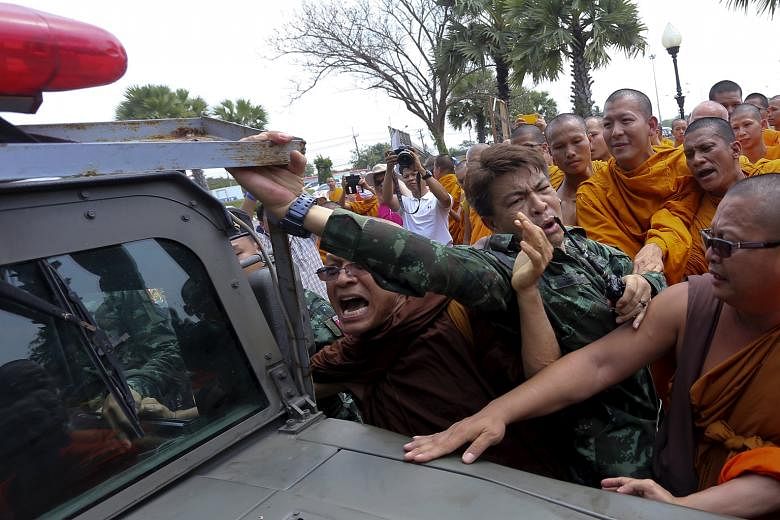 Buddhist monks in a scuffle with soldiers during a protest in Nakhon Pathom province west of Bangkok yesterday. Around 3,000 monks gathered for a seminar there to support abbot Somdej Chuang, the front runner for the post of Thailand's Supreme Patria