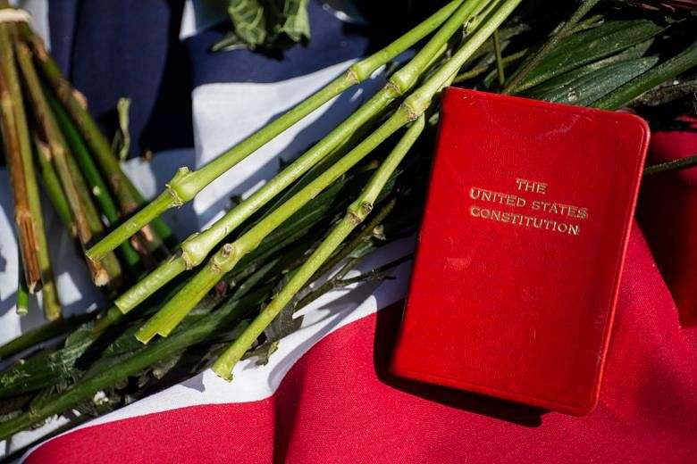 A copy of the US Constitution rests among tributes outside the Supreme Court in Washington for Justice Scalia, who died last Saturday. The White House has vowed to select a nominee within weeks.