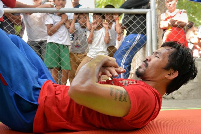 Children watch Manny Pacquiao work out at a sports complex in General Santos in the Philippines, in preparation for his April 9 bout against Timothy Bradley in the US.