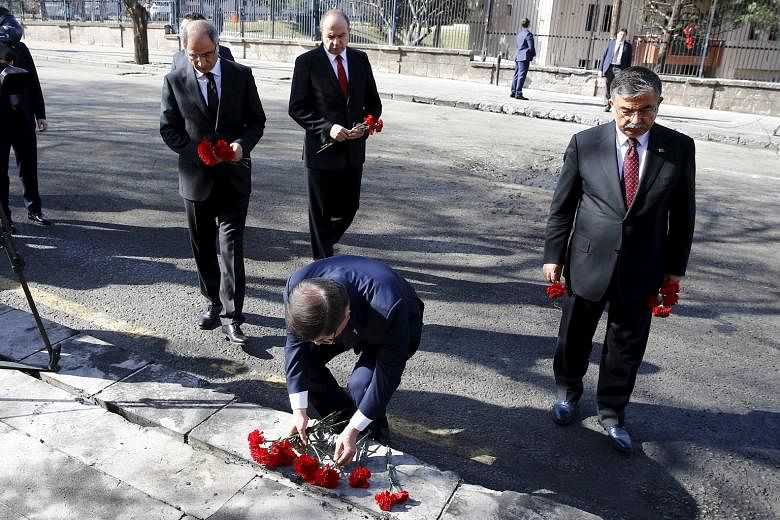 Turkish Prime Minister Ahmet Davutoglu placing flowers at the site of Wednesday's suicide bomb attack in Ankara that killed 28 people. Turkey says the YPG was behind the attack, but the US says it is not in a position to confirm or deny Ankara's accu