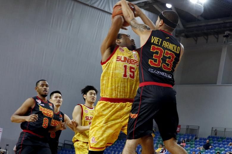 The Singapore Slingers' Xavier Alexander (No. 15) is blocked by the Saigon Heat's David Arnold, as he goes up for a shot in their Asean Basketball League game at the OCBC Arena yesterday. The Slingers rounded off their regular season with a 100-73 wi