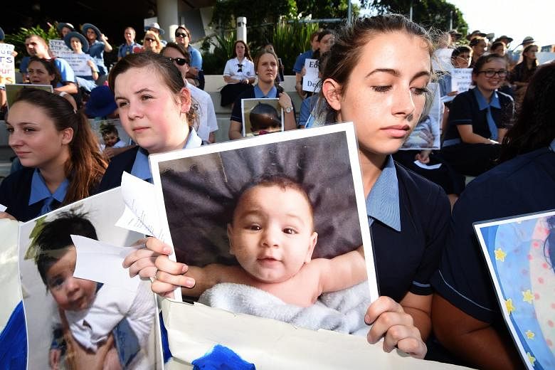 Students in Brisbane with photos of baby Asha during a protest last week outside the hospital where she was being treated for burns. Yesterday, Asha and her mother were released into community detention but Immigration Minister Peter Dutton insists t