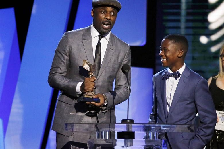Idris Elba (left) accepting the award for Best Supporting Male for his role in Beasts Of No Nation as co-star Abraham Attah looks on.