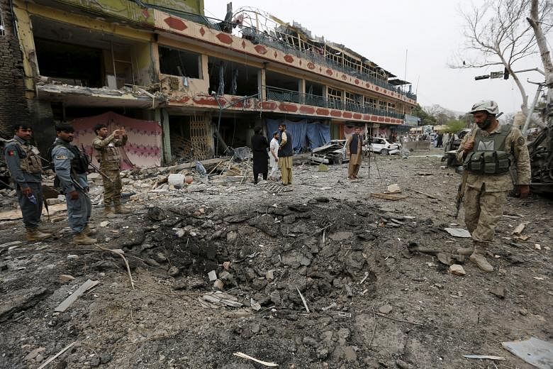 Afghan policemen inspect the site of the blast near the Indian consulate in Jalalabad.Two people were killed and 19 wounded. No group has claimed responsibility for the attack.