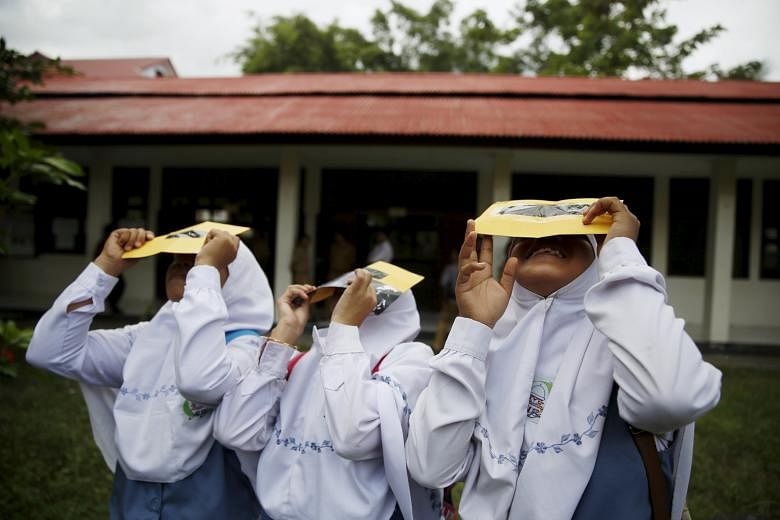 Students at a school in Ternate island, in eastern Indonesia, testing their self-made filters to look at the sun after a joint workshop between the Hong Kong Astronomical Society and Indonesia's National Institute of Aeronautics and Space. The total 