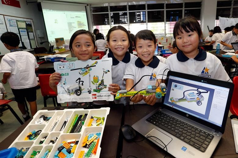 (From left) North View Primary School pupil Nurul Insyirah Jamaludin and her classmates, Chloe Lee, Olivia Koh and Florence Lee, all nine years old, showing off their robotic toy, which they built by tinkering with Lego bricks, motors and sensors. On